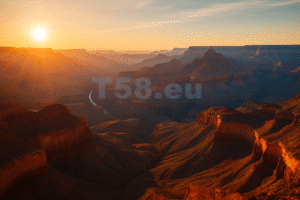 A Grand Canyon naplementekor, ahogy az aranyló fény megvilágítja a szurdok mélyén kanyargó Colorado folyót és a rétegzett sziklafalakat.